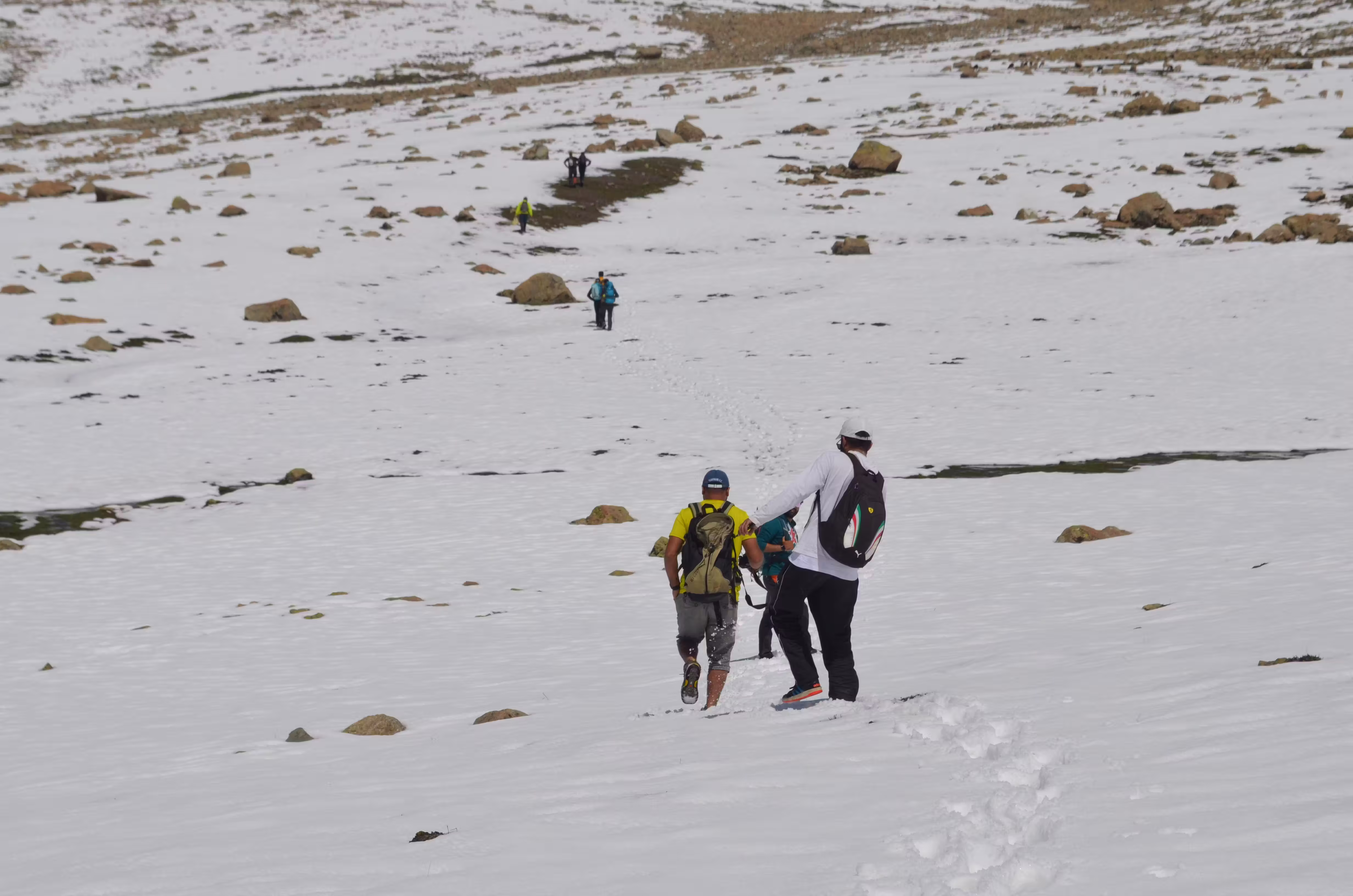 Traveler sitting on a rocky cliff enjoying the breathtaking mountain valley view